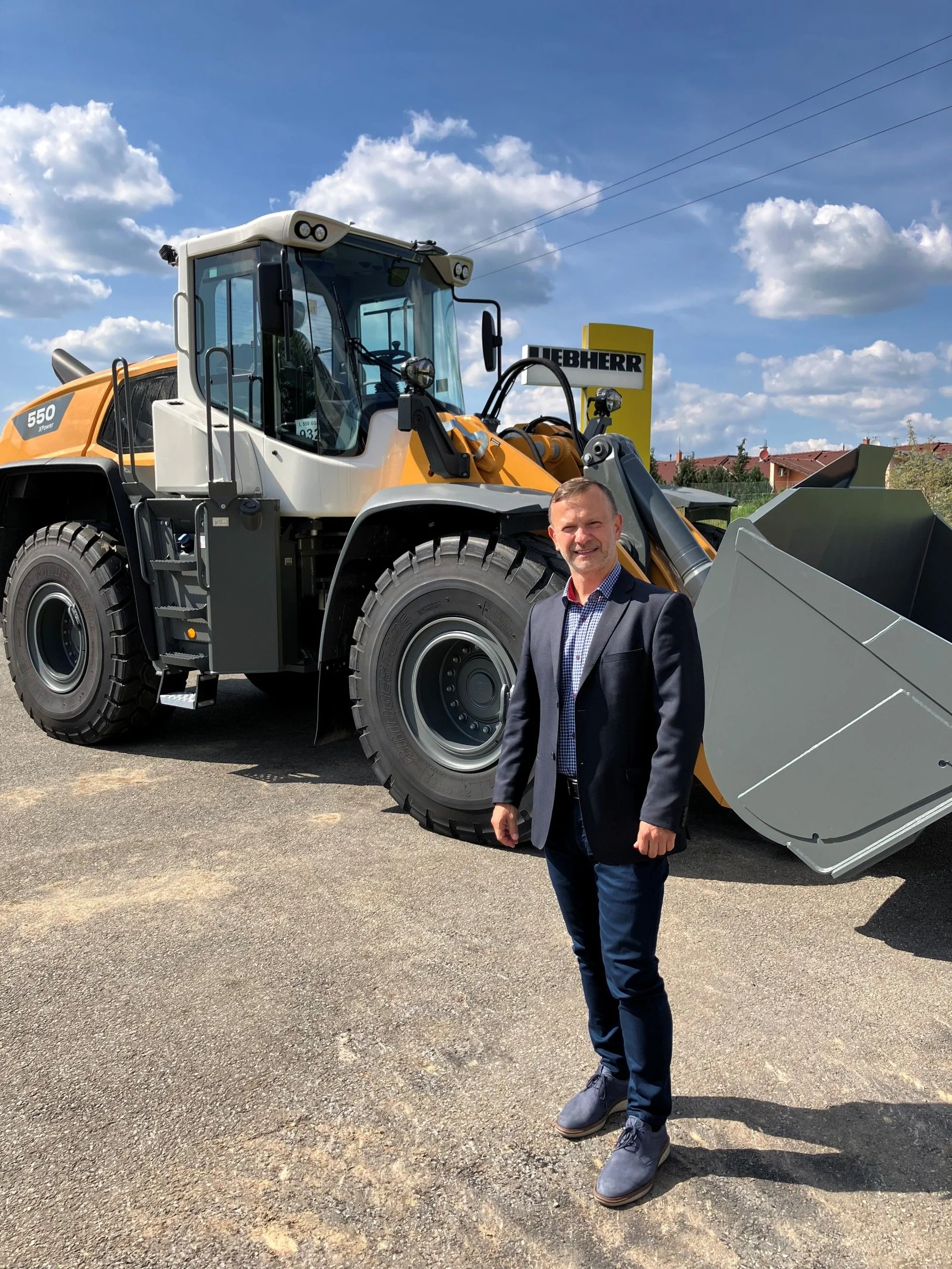 Jaroslav Moravec stojí před bagrem značky Liebherr CZ s. r. o.